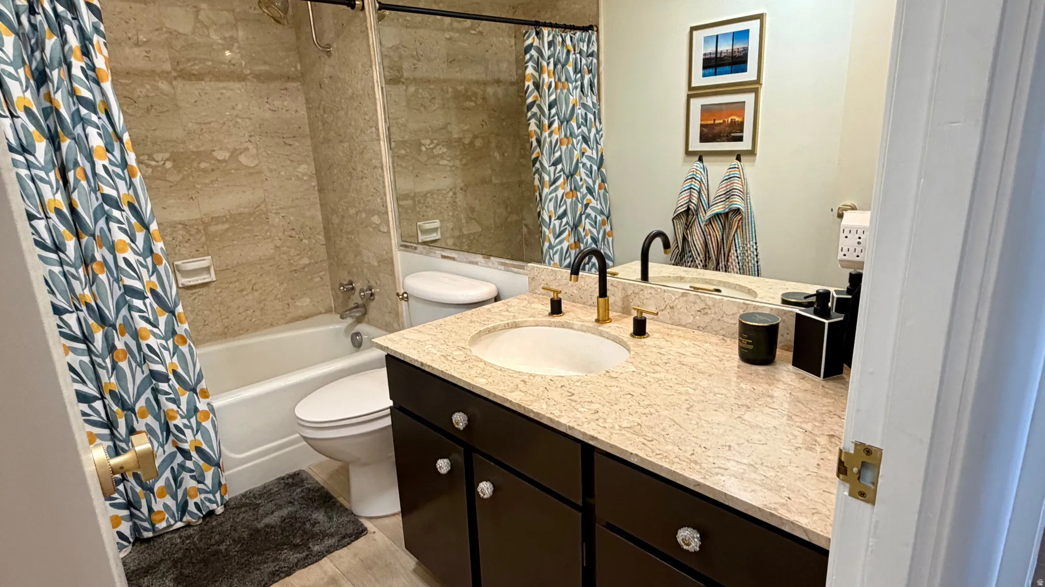 Bathroom featuring a vanity with a light-toned countertop, integrated sink, and dark cabinetry with crystal-style pulls