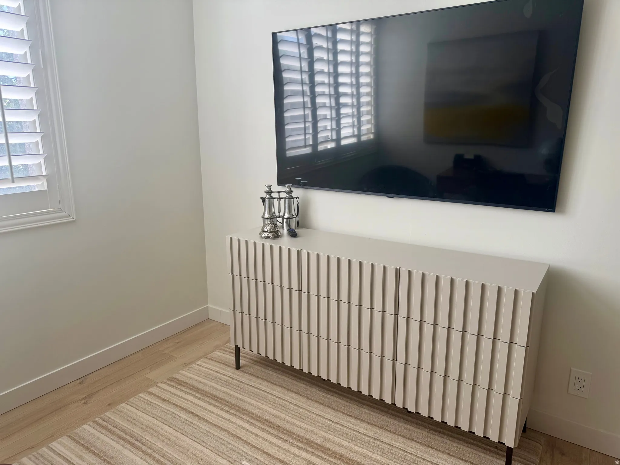 Light-toned wall with integrated wall-mounted media console