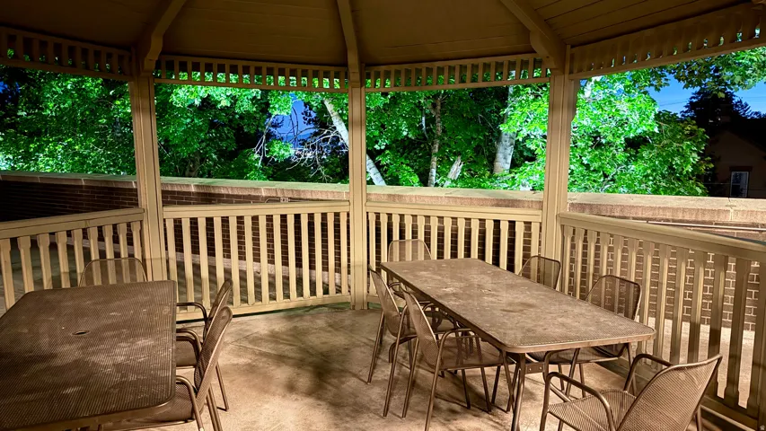 Gazebo structure featuring open-slat railings and an open lattice ceiling
