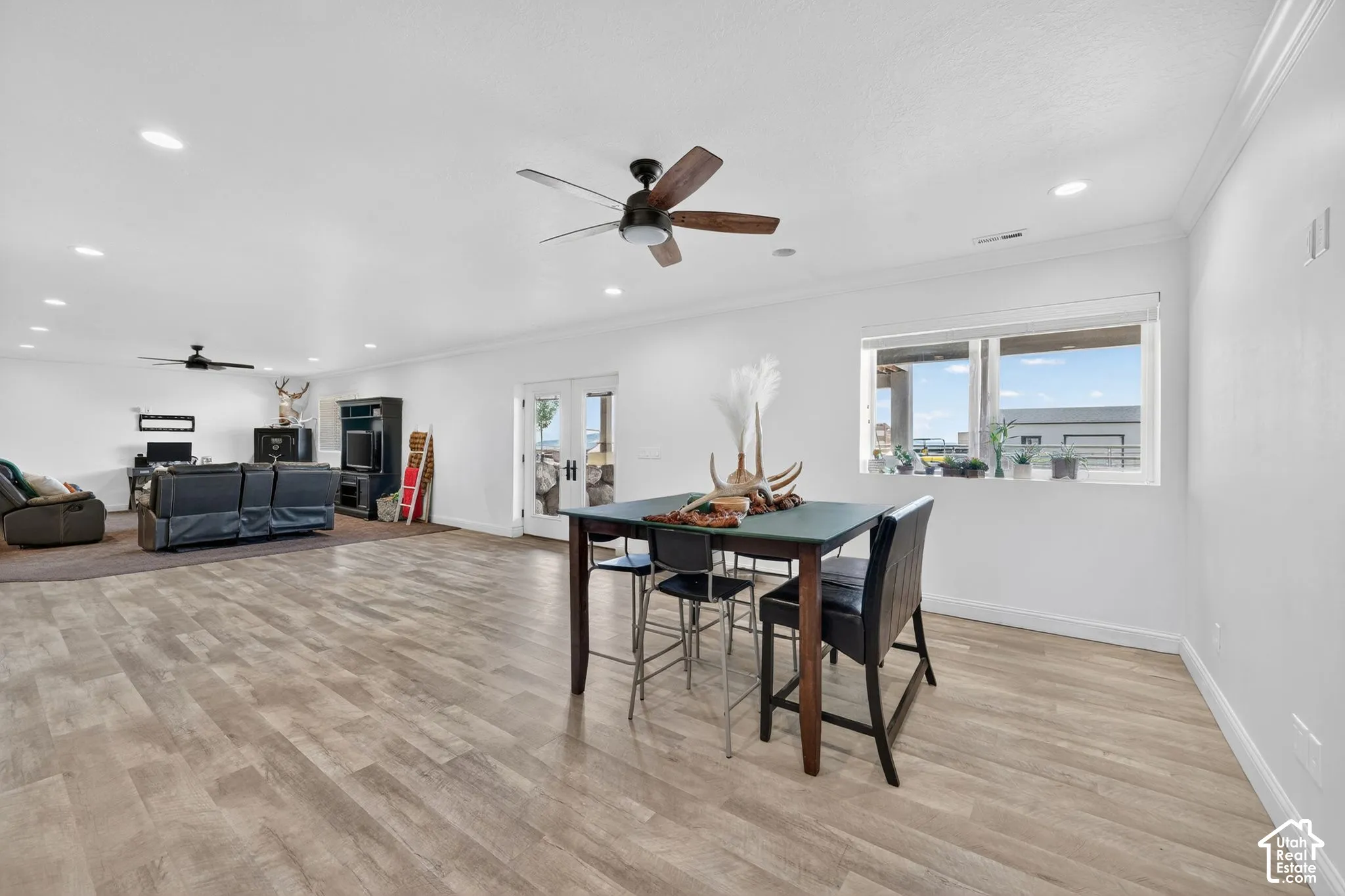 Spacious open-concept room featuring wood-finish flooring, white walls, and recessed lighting