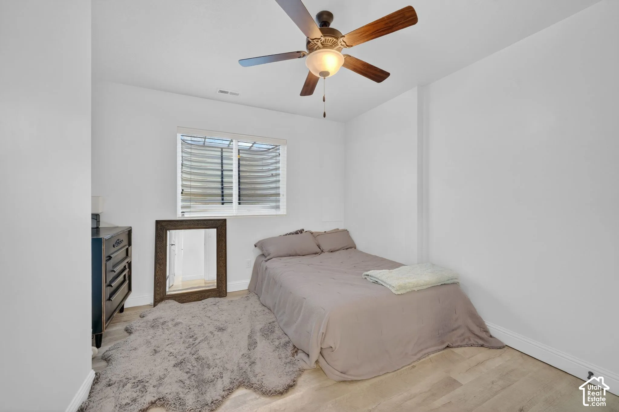 Room with light wood-finish flooring and a ceiling fan with integrated lighting