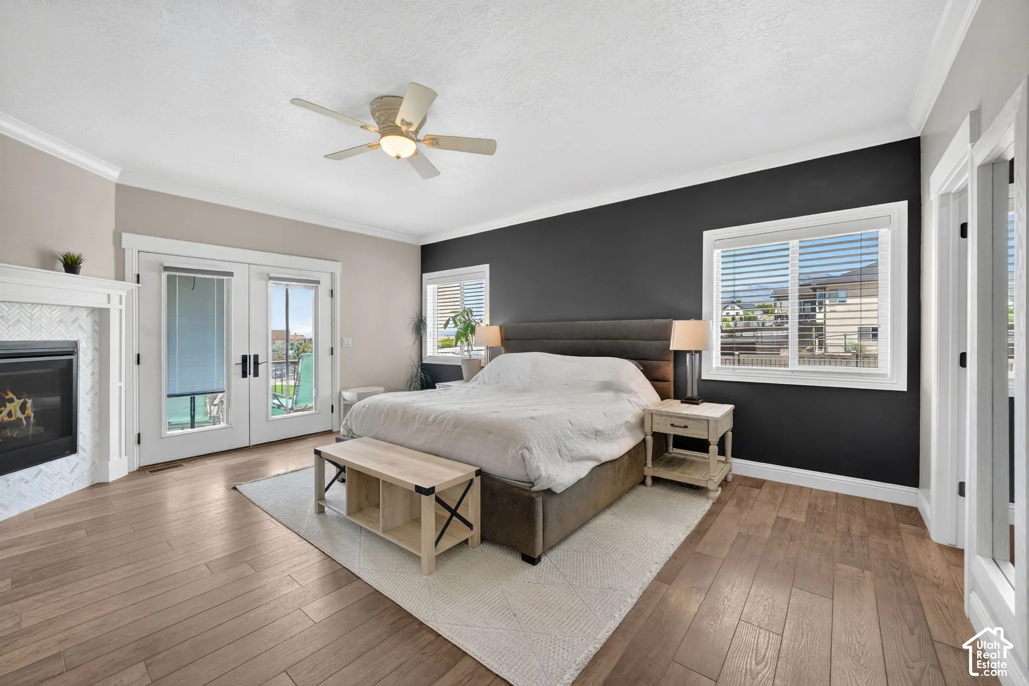 Spacious room featuring wood-finish flooring, a ceiling fan, and crown molding