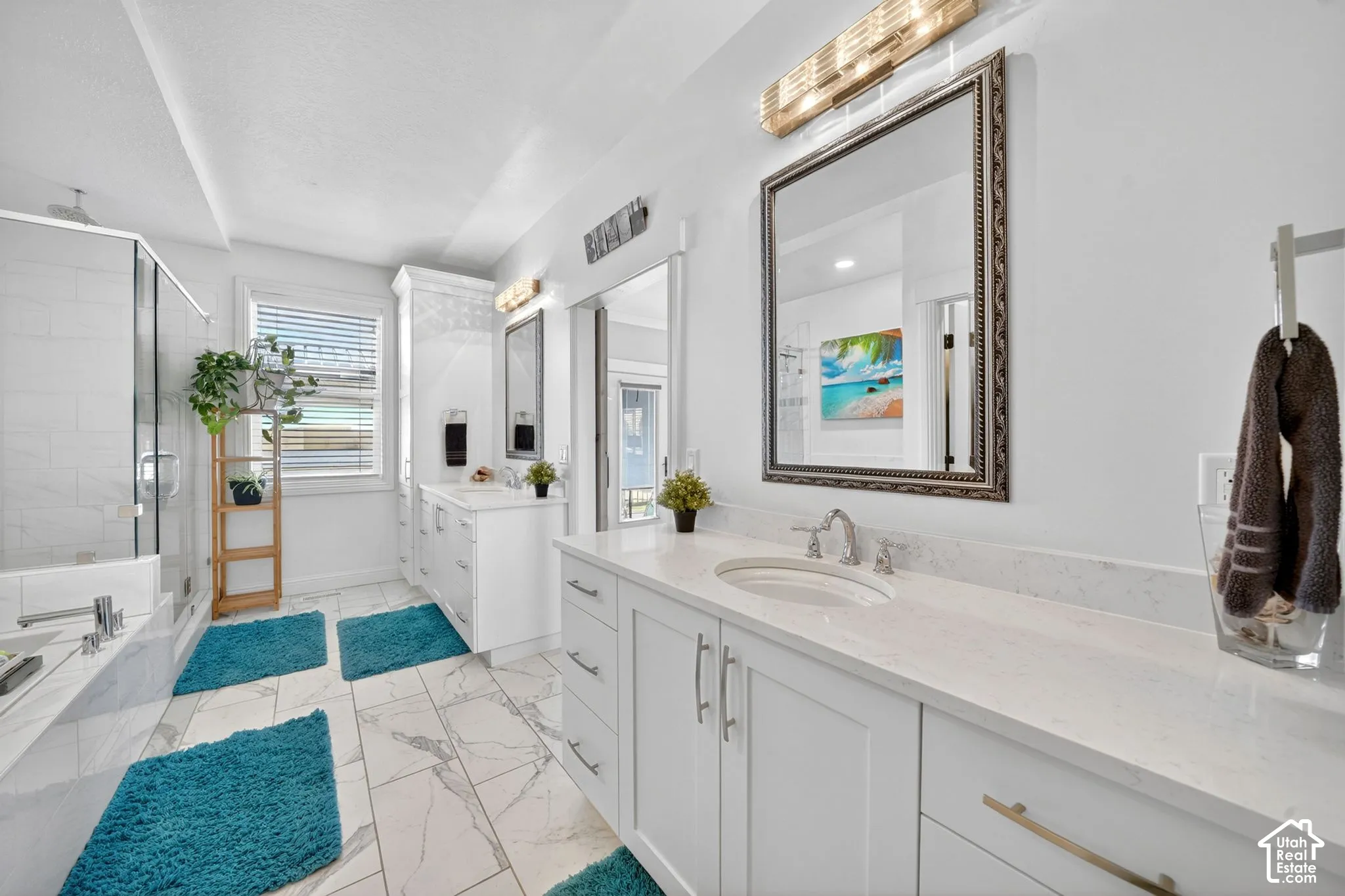 Bright bathroom featuring dual vanity with stone countertops, modern cabinetry, and individual framed mirrors