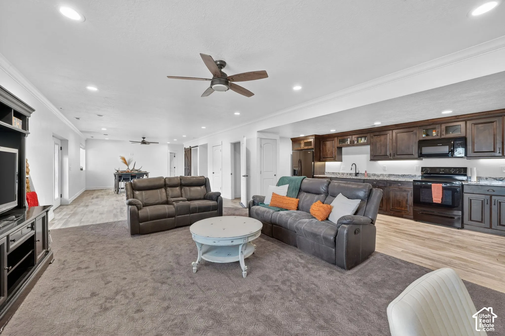 Spacious living area featuring recessed lighting, a ceiling fan, and dark wood-finish cabinetry