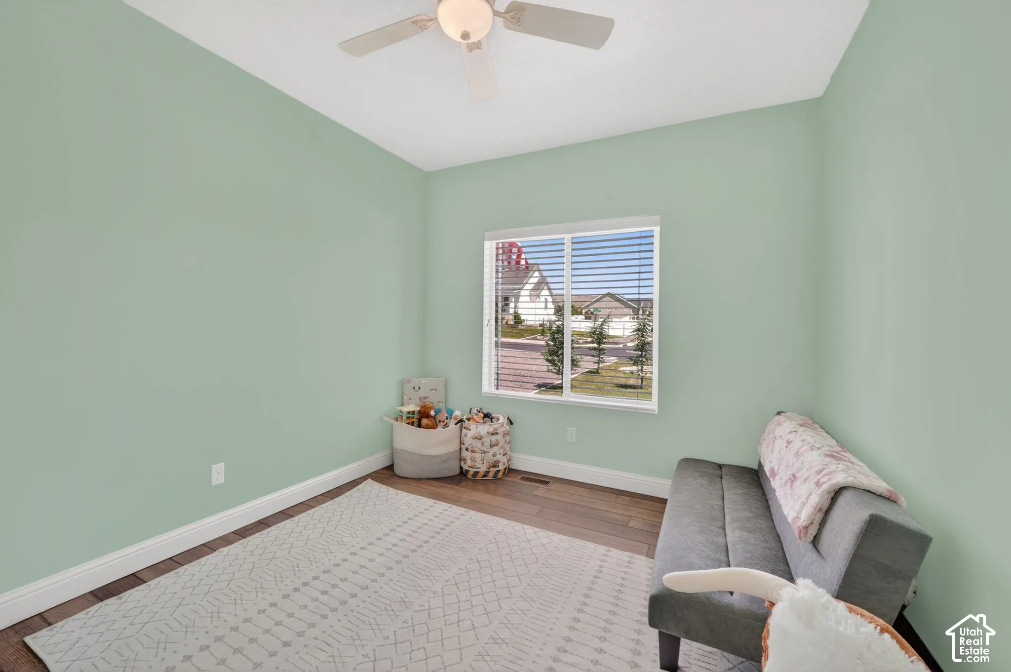 Bright room with light green walls and wood-finish flooring