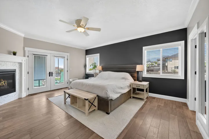 Spacious room featuring wood-finish flooring, a ceiling fan, and crown molding