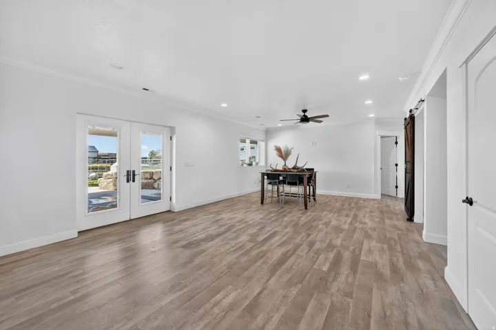 Spacious interior featuring wood-finish flooring, white walls, and French doors leading to an exterior area