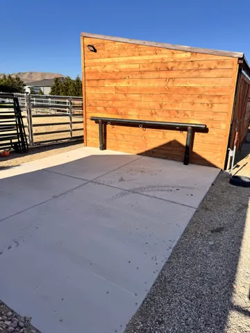 Wood-paneled shed with an attached metal hitching rail