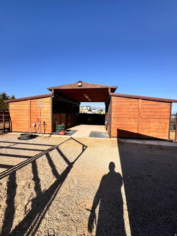 Wood-paneled outbuilding with a central breezeway and two covered wings