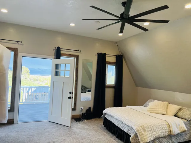 Attic space featuring a ceiling fan with integrated lighting, recessed overhead lighting, and sloped ceilings