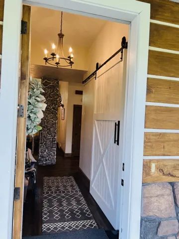 Entryway featuring a white barn door on a black metal track