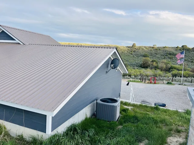 Corrugated metal roofing atop a charcoal-colored exterior siding with white trim