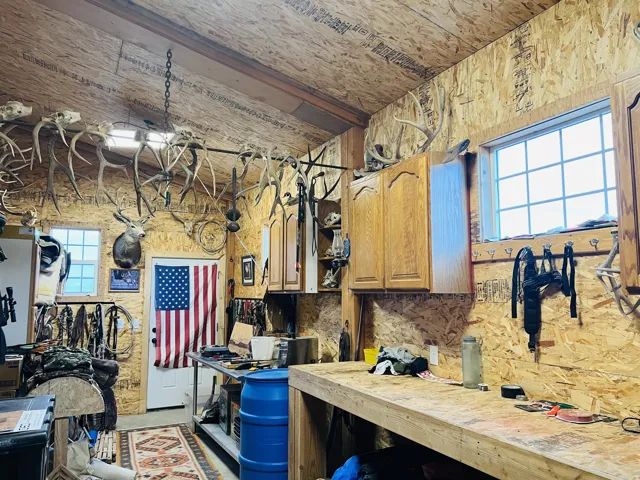 Interior space featuring wood-finish walls and ceiling, two windows with gridded panes, built-in wooden cabinetry, and an exposed ceiling beam