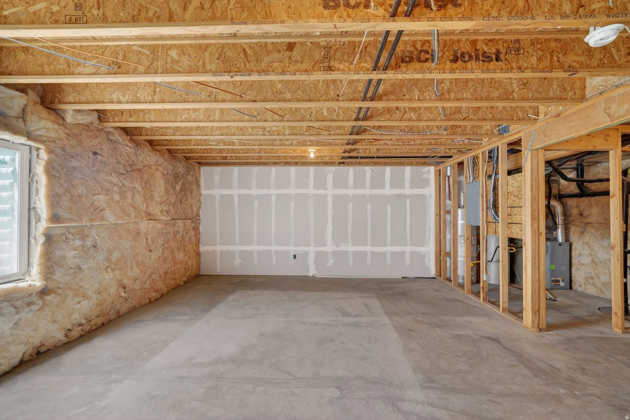 Unfinished interior space featuring exposed wood joists and subflooring