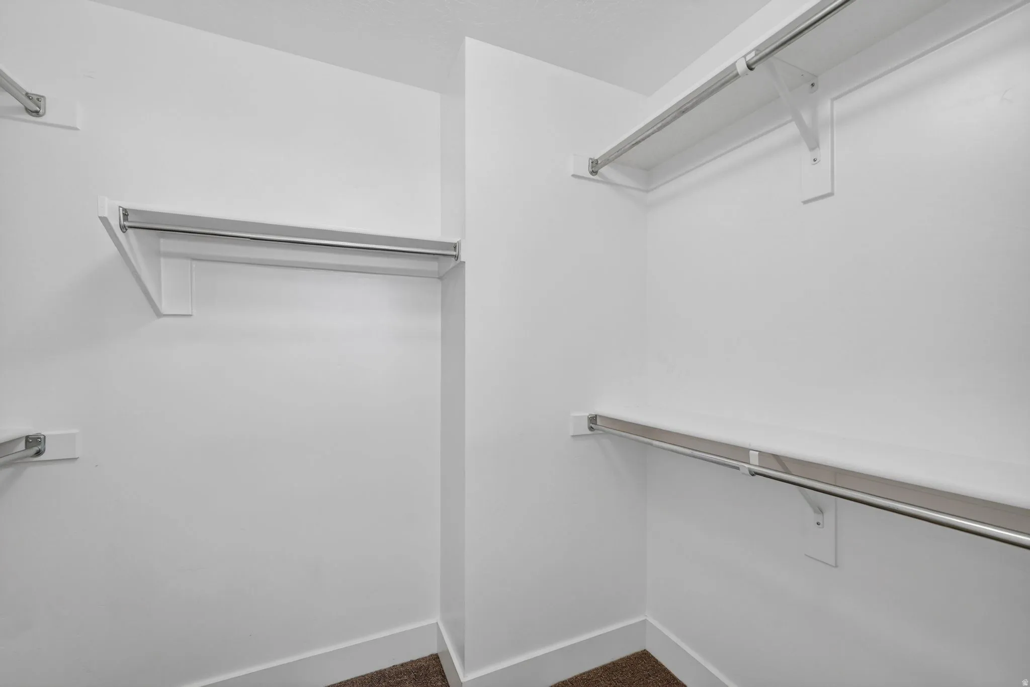 Integrated closet system featuring multiple white shelves and chrome hanging rods