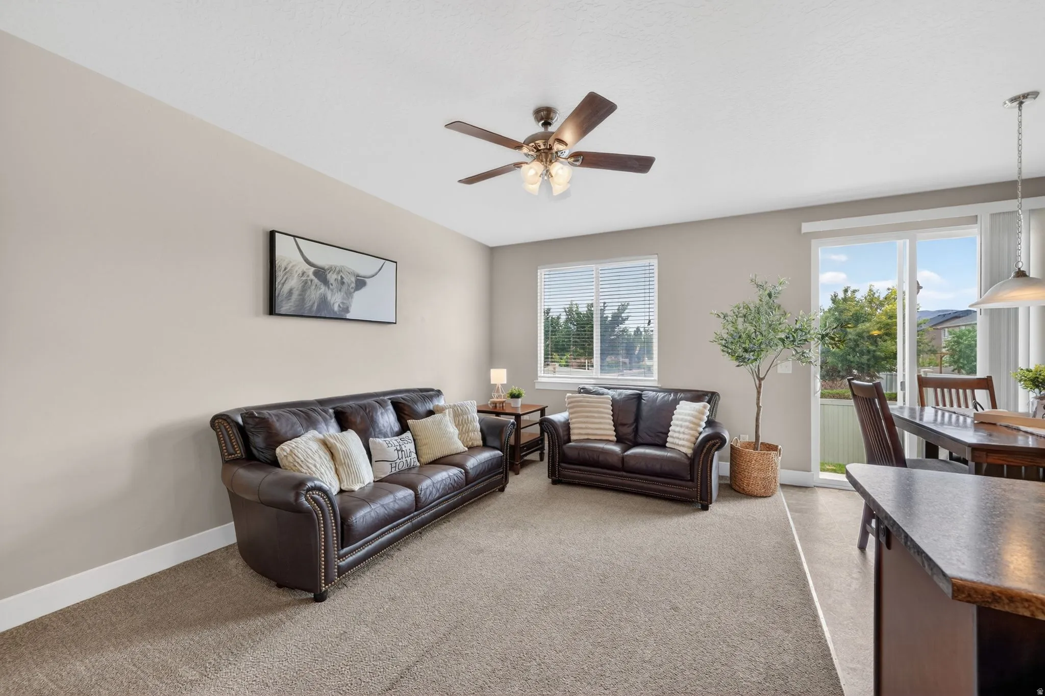Open-concept living area featuring neutral-toned walls, recessed lighting, and a ceiling fan with integrated lighting