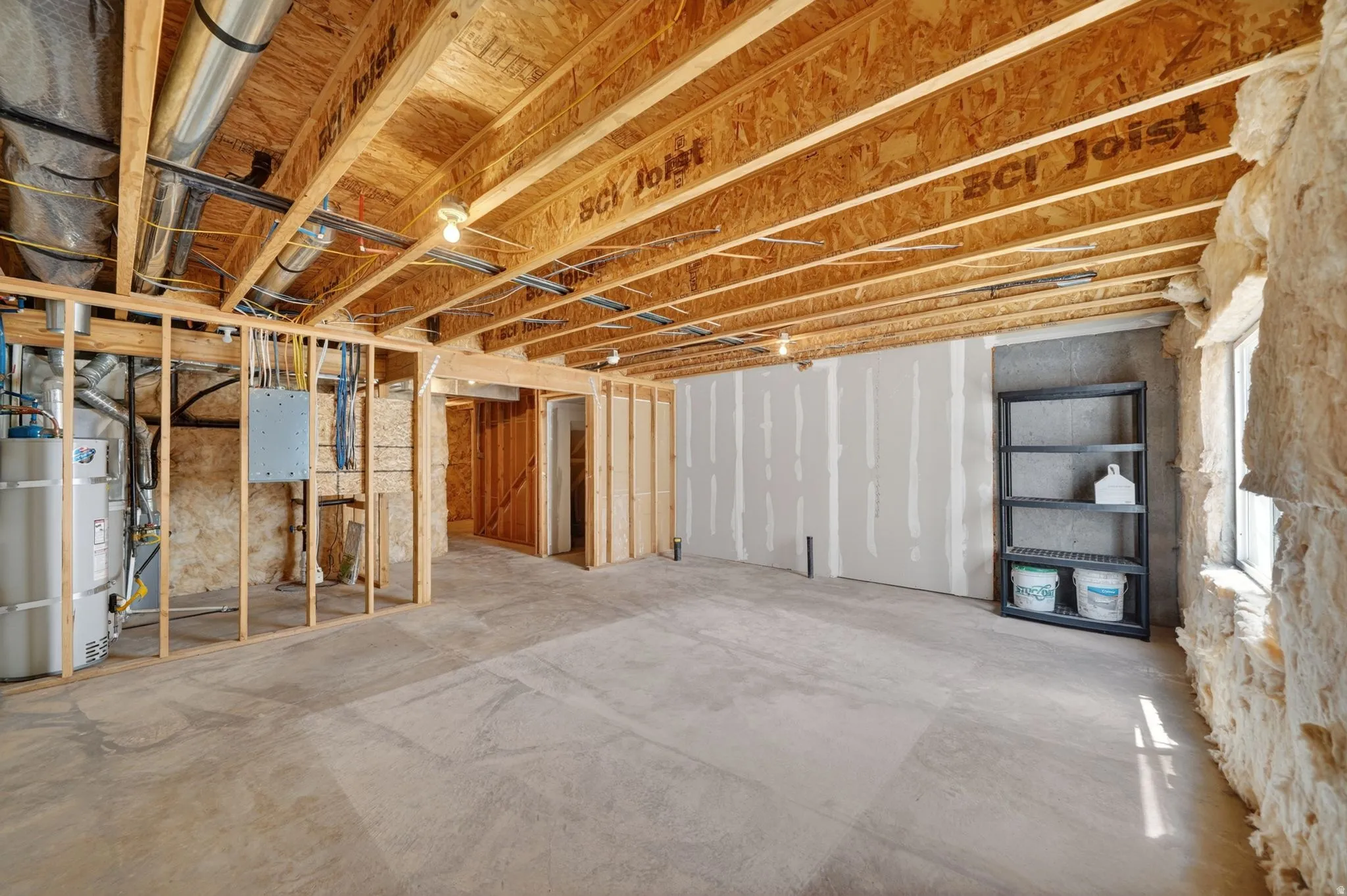 Unfinished basement area with exposed wood framing, concrete flooring, and visible ceiling joists