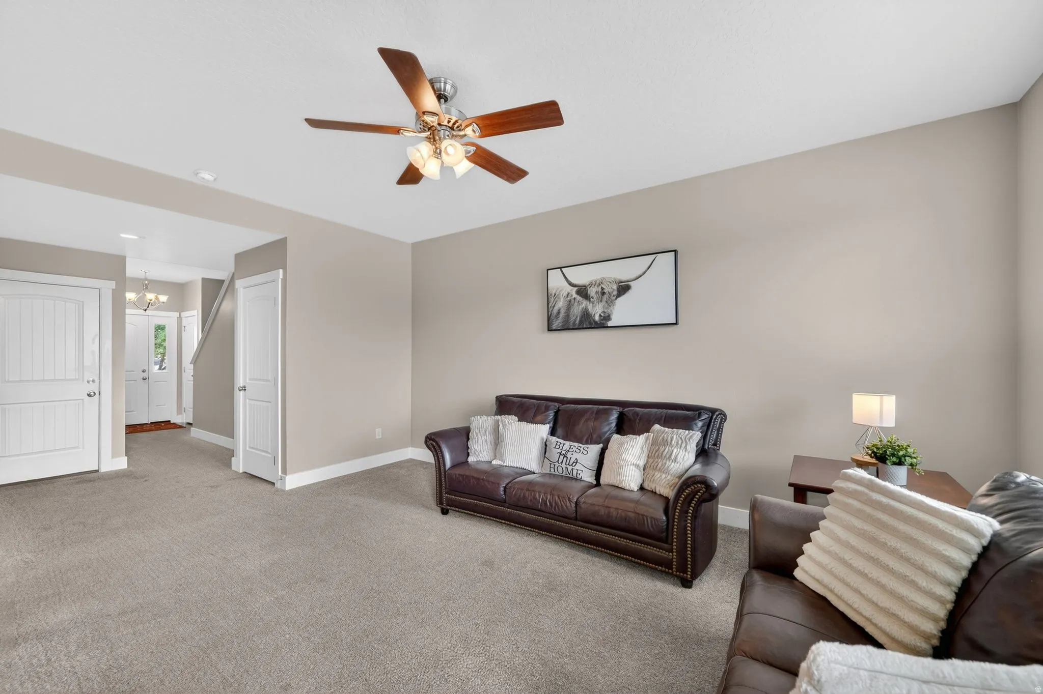 Spacious living area featuring neutral-toned walls, recessed lighting, and a wood-bladed ceiling fan