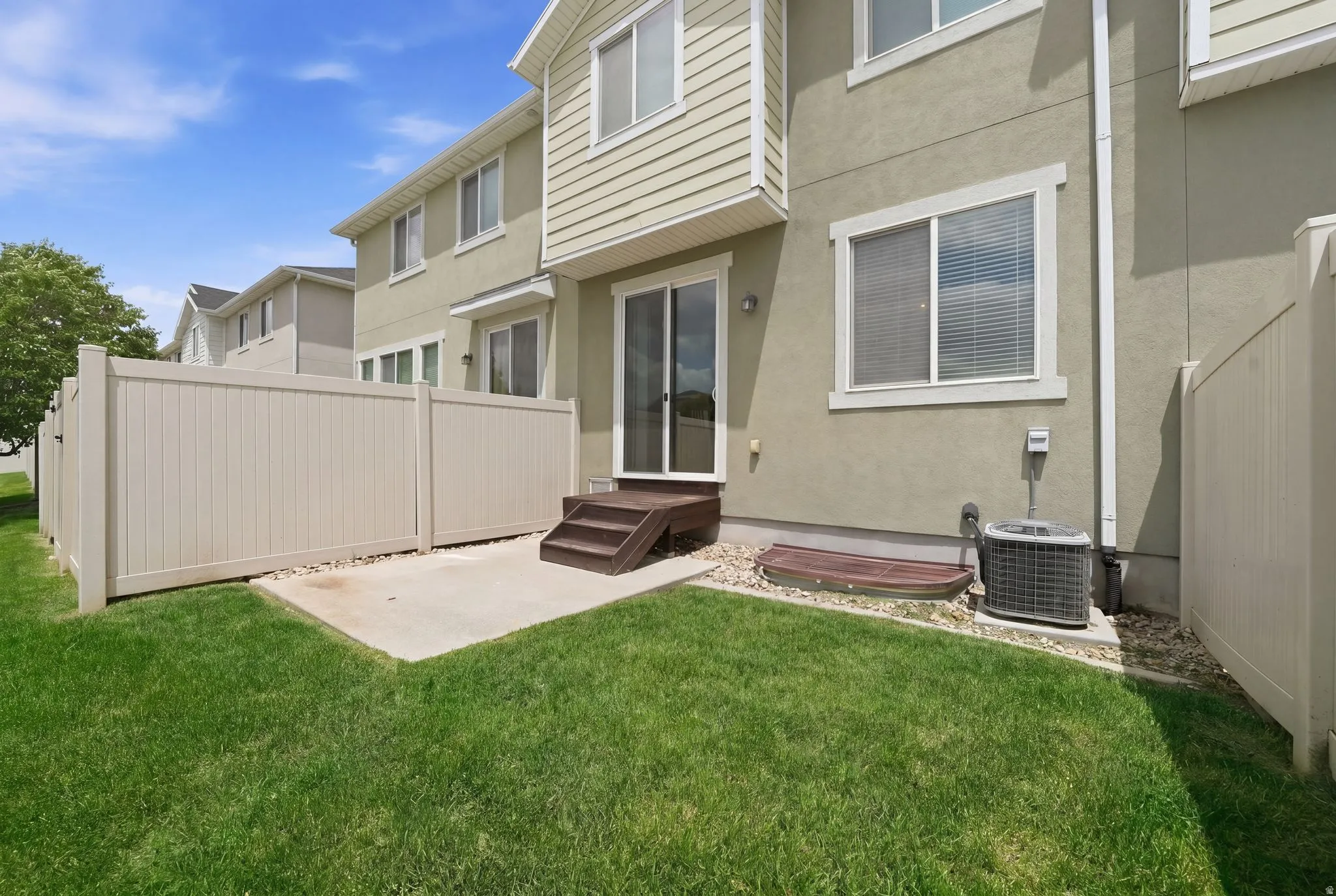 Private fenced yard with a concrete patio and direct access to the interior via a sliding glass door