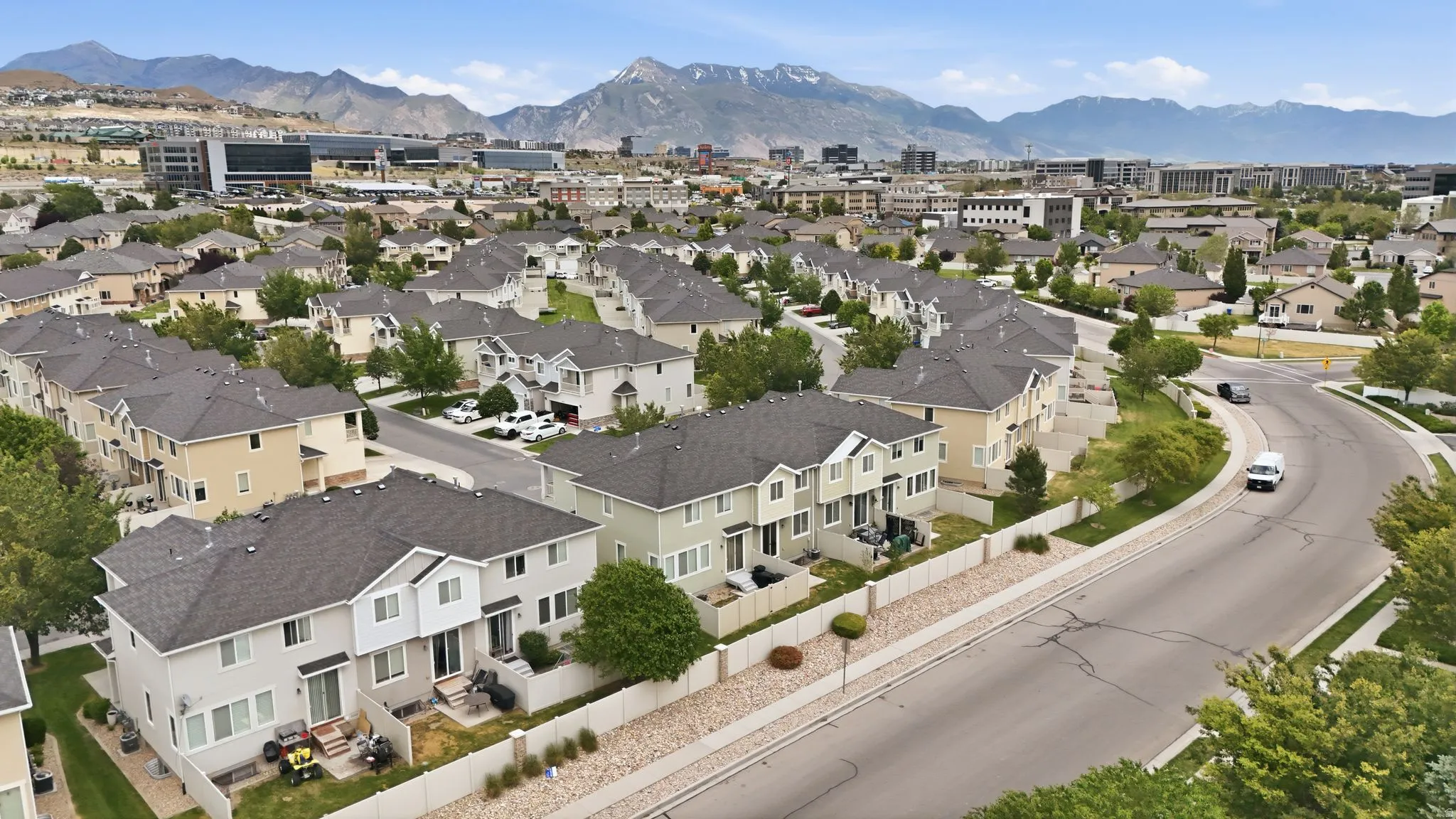 Aerial perspective showcasing a residential community with multi-story townhomes and detached single-family residences