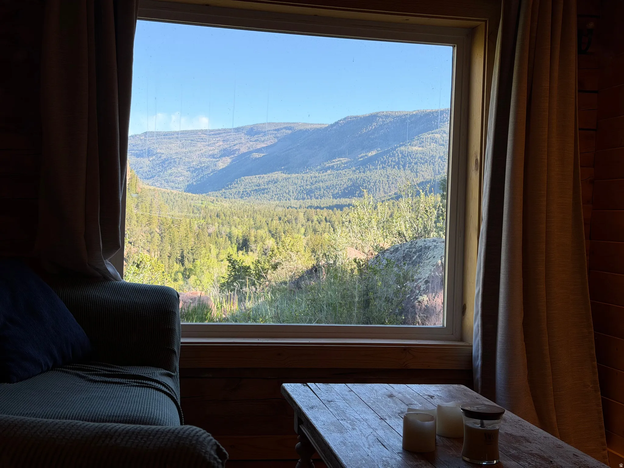 Expansive picture window framing mountain and forest scenery