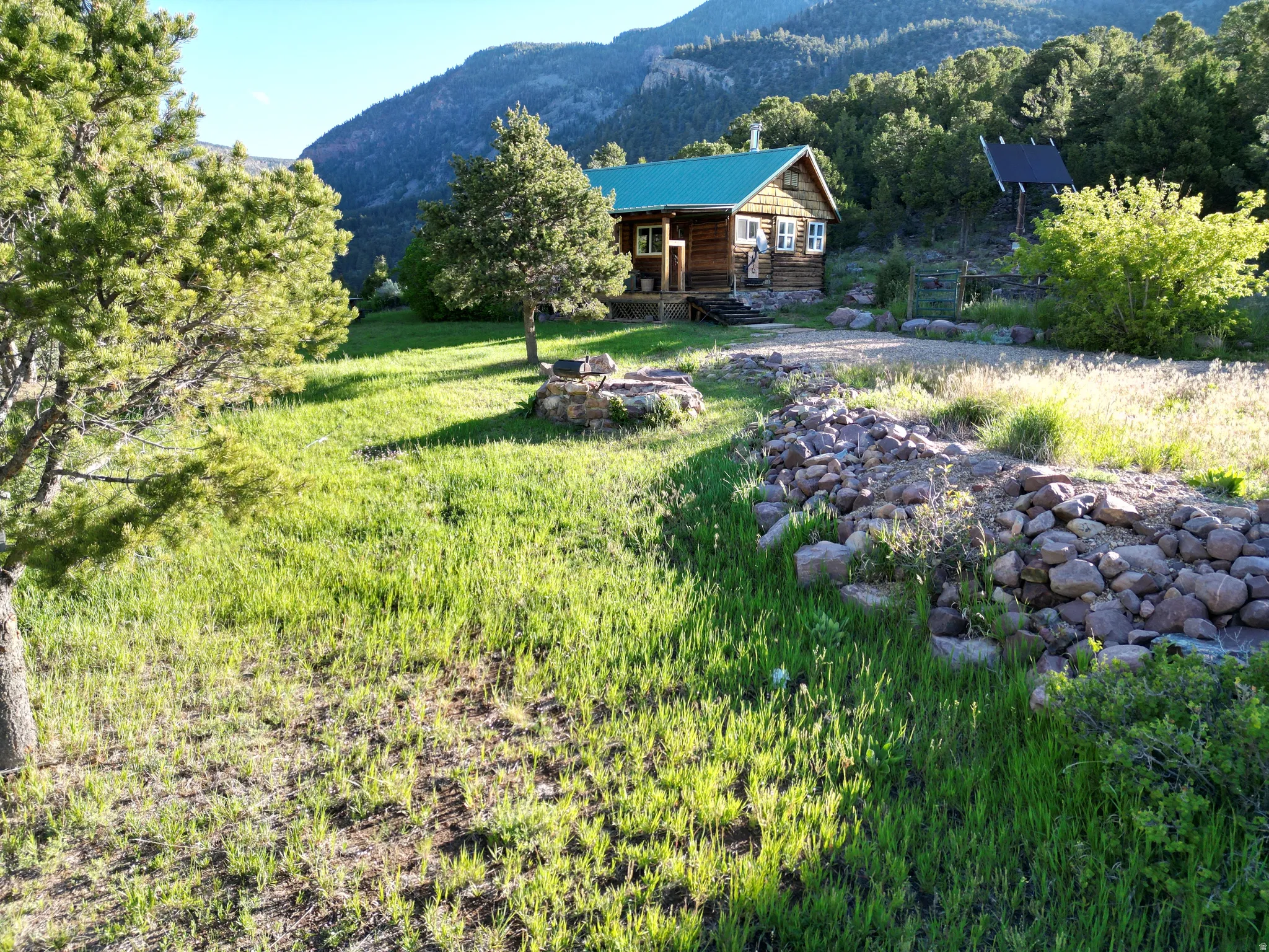 Rustic log cabin structure with a green metal roof