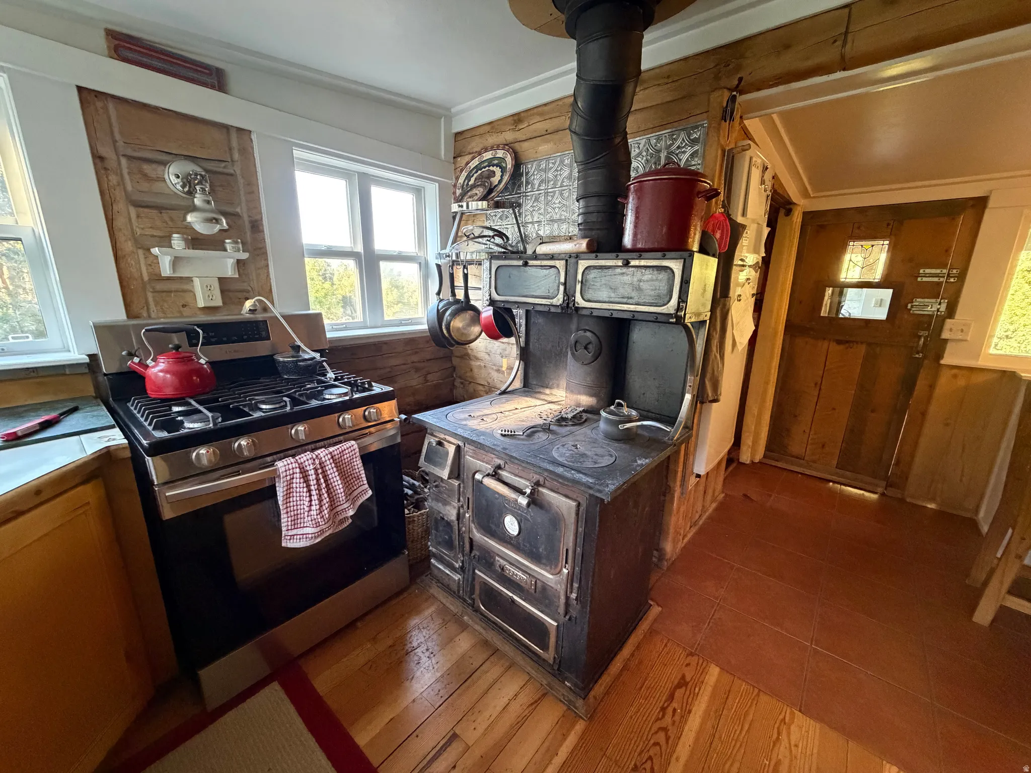Rustic kitchen featuring light wood paneling and wood-finish flooring