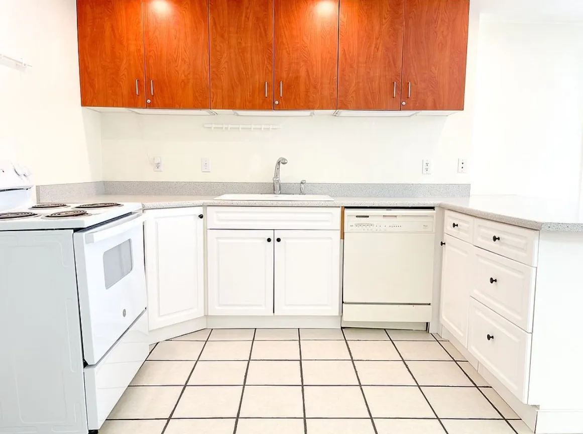 2nd Kitchen for ADU featuring wood-finish upper cabinetry and white lower cabinetry with black hardware
