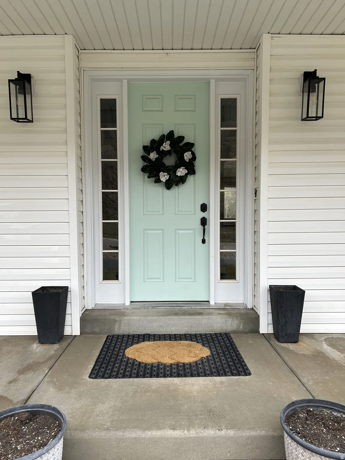Light mint entry door with sidelights, featuring white trim and black hardware
