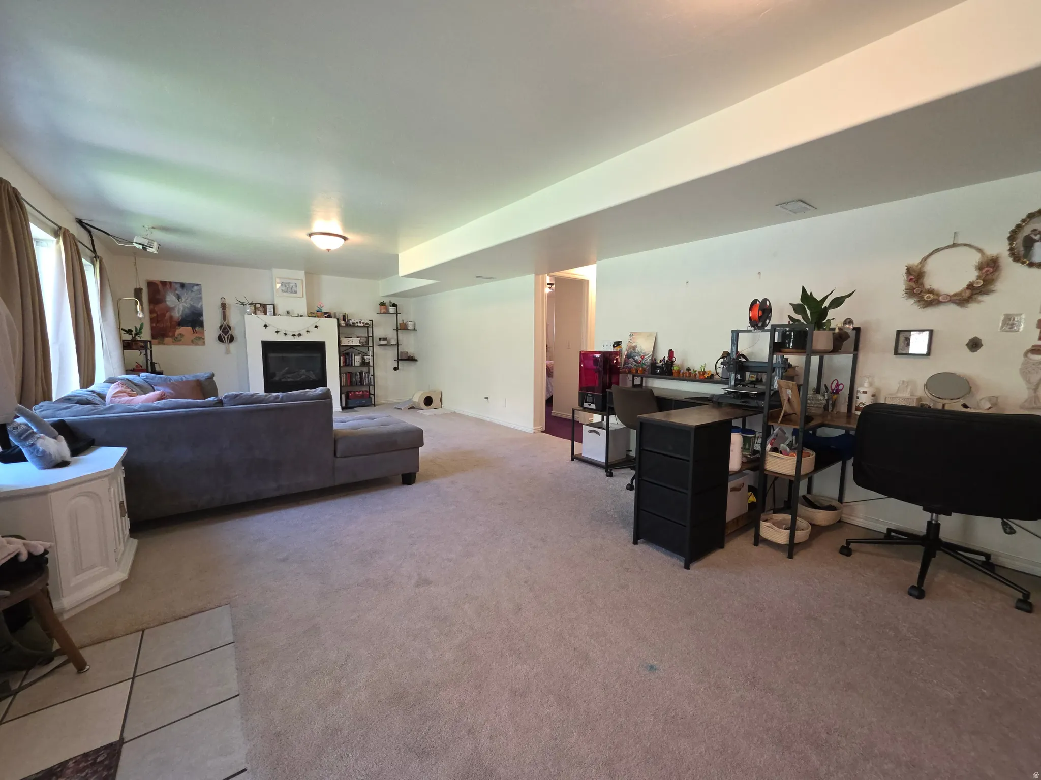 Spacious living area featuring neutral carpeting, recessed lighting, a fireplace with a white mantle, and a white ceiling