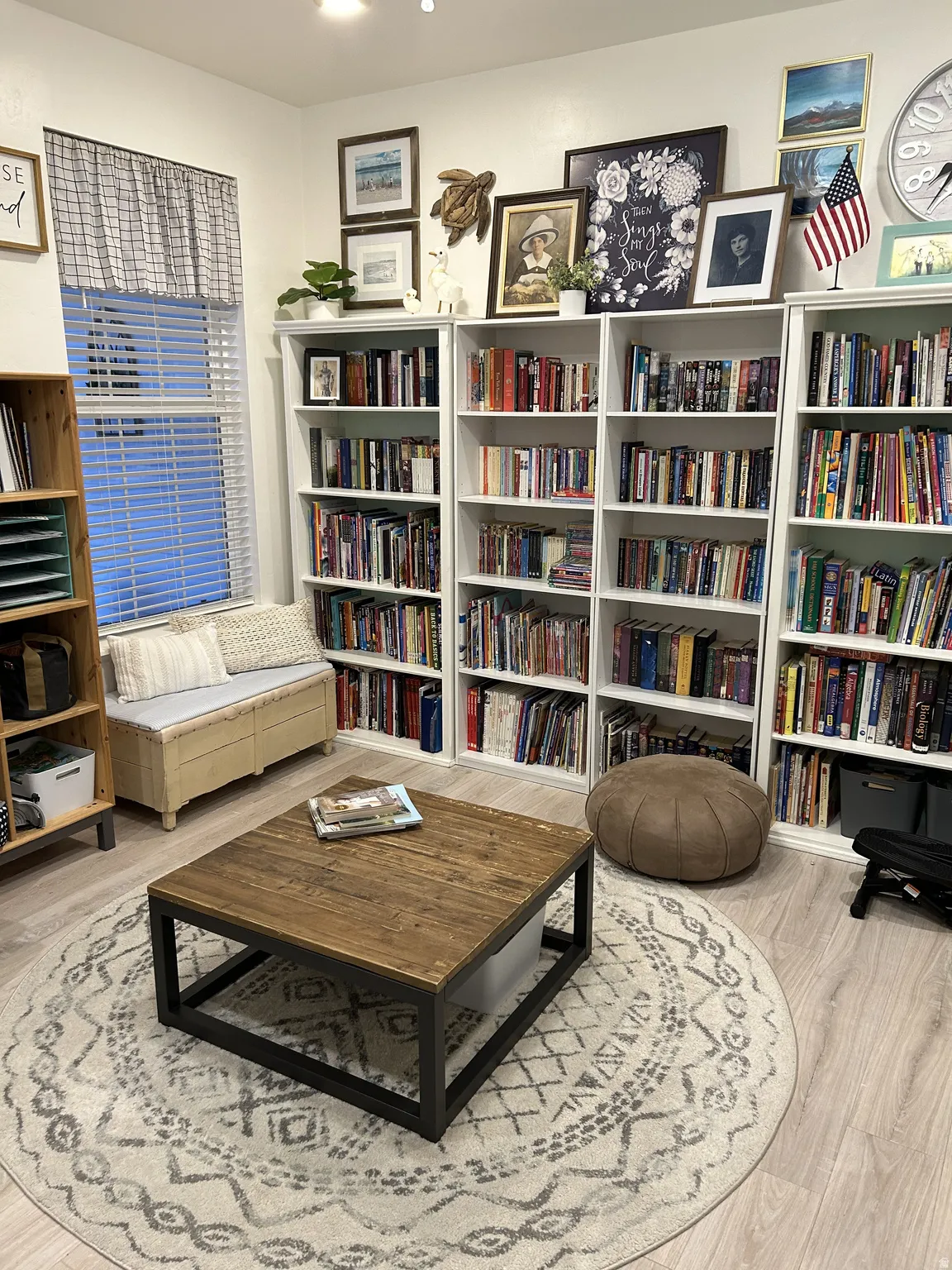 Built-in shelving units, wood-finish flooring, a window with blinds, and recessed lighting create a functional space