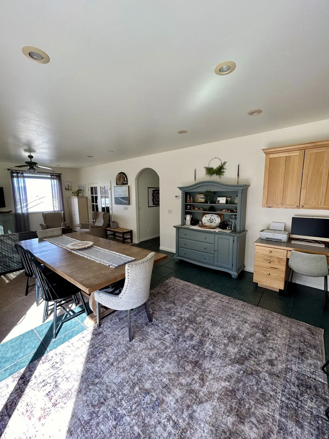 Open-concept living space featuring recessed lighting, a ceiling fan, and dark-toned tile flooring