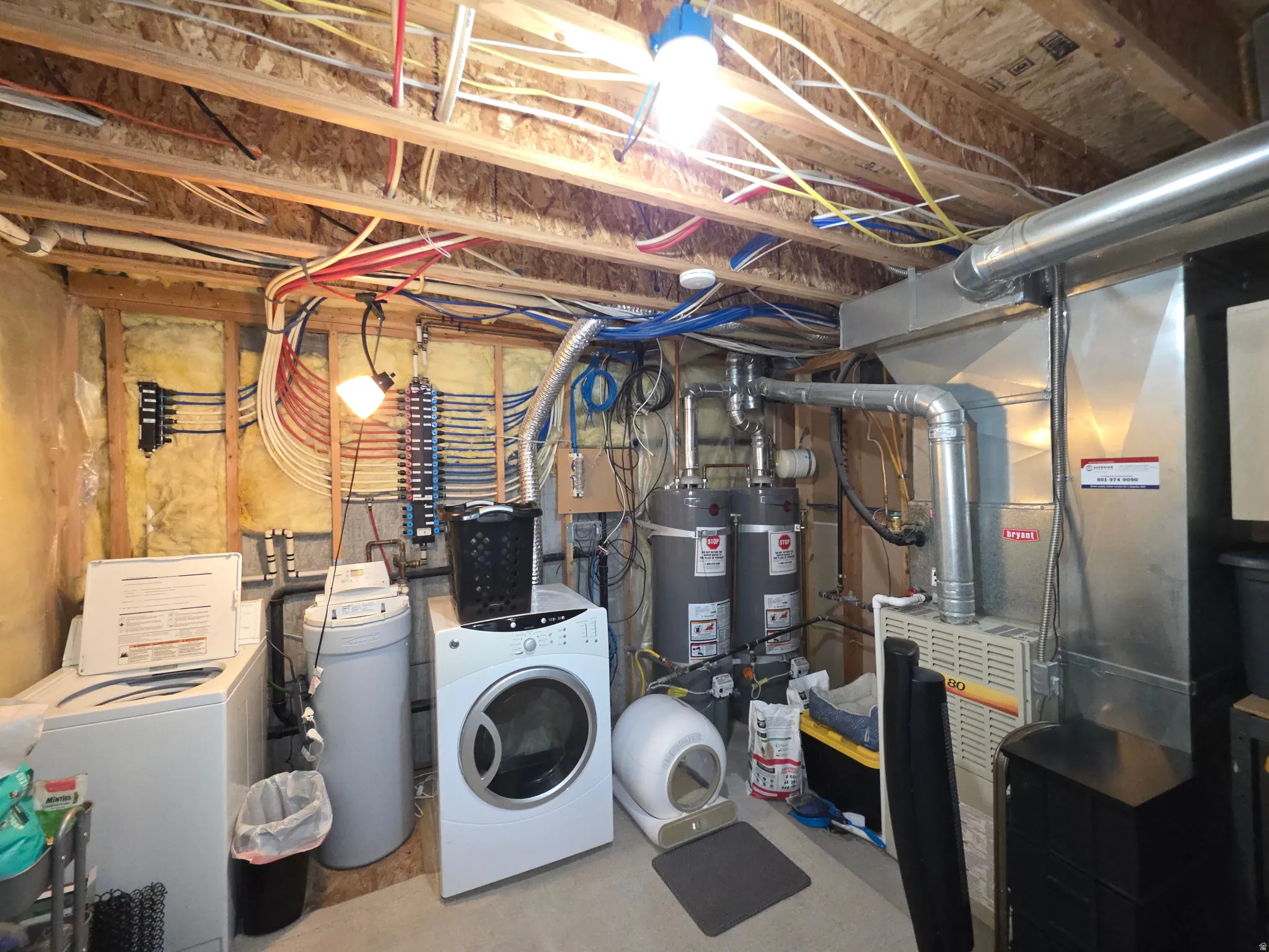 2nd laundry area, utility area featuring a water softener system, two water heaters, and a forced-air furnace