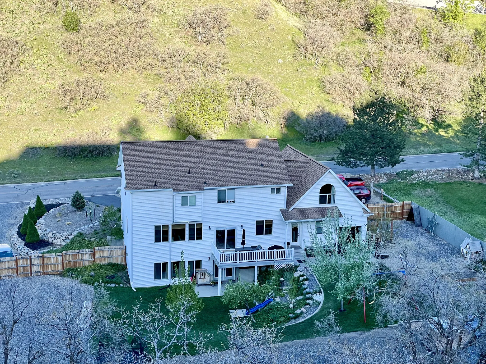 White exterior home with multiple large windows and a peaked roofline