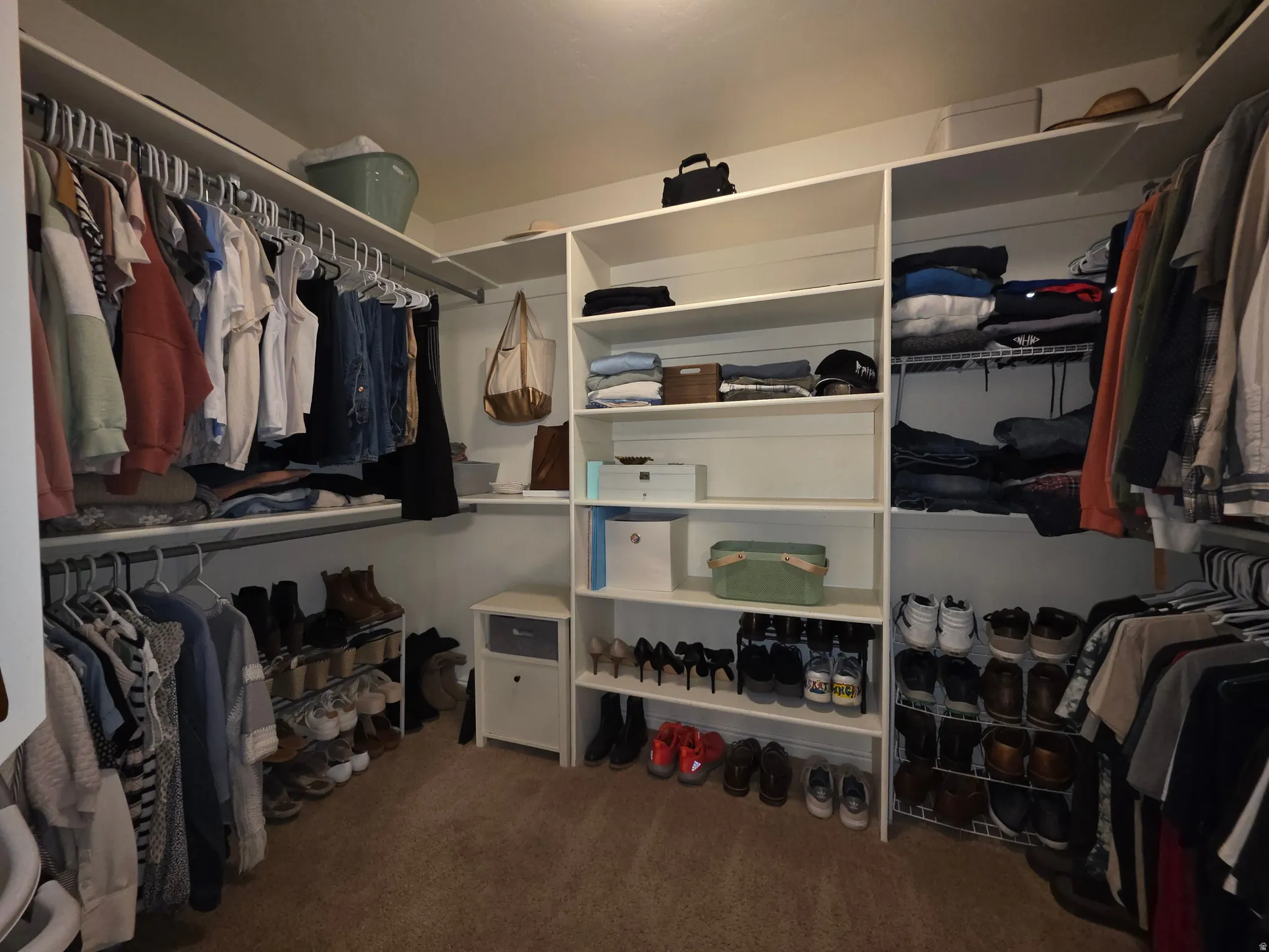 Owner's walk-in Custom closet system featuring extensive shelving, multiple hanging rods, and integrated shoe storage