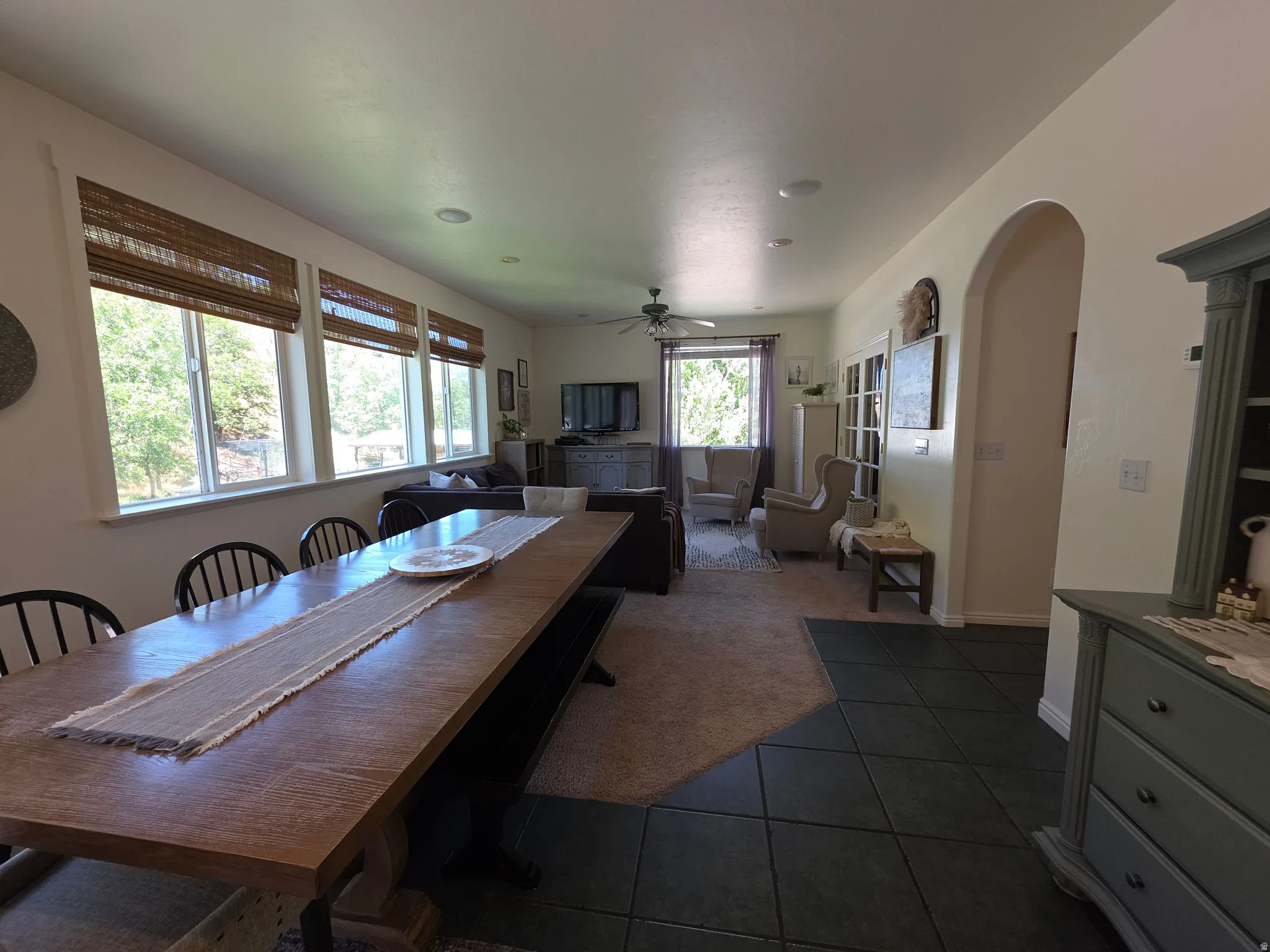Expansive dining area featuring a long wood-finish table and black spindle-back chairs
