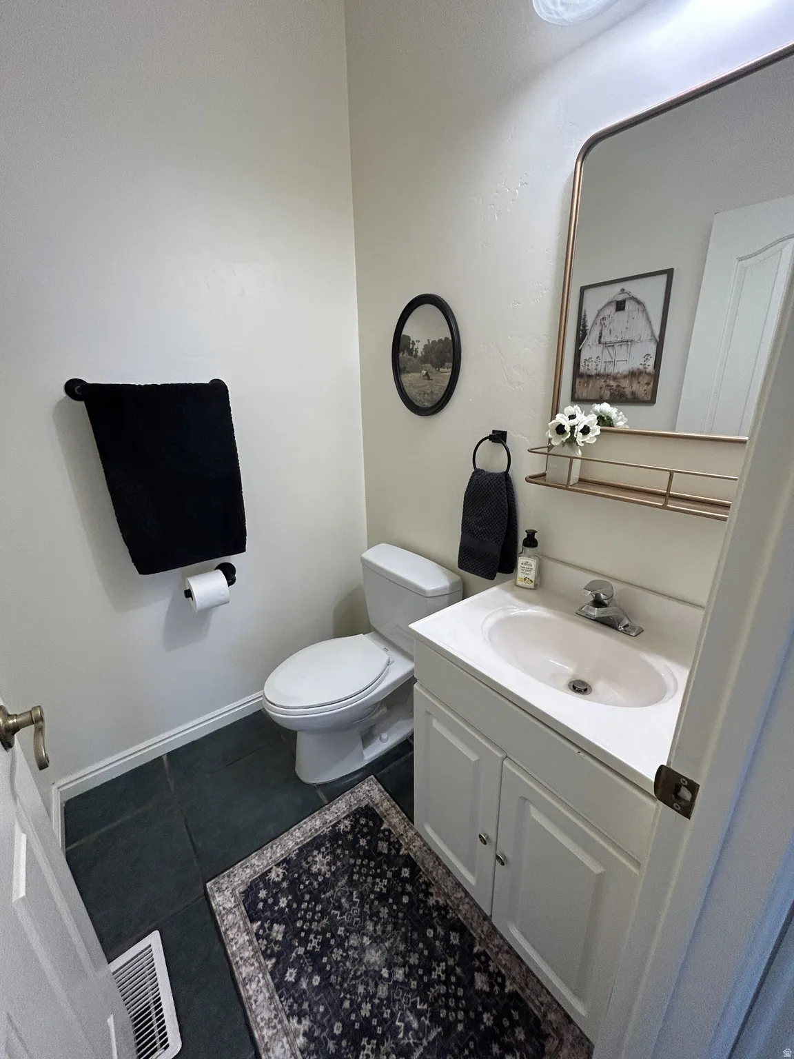 1/2 Bathroom featuring a white vanity with panel cabinetry and a white countertop