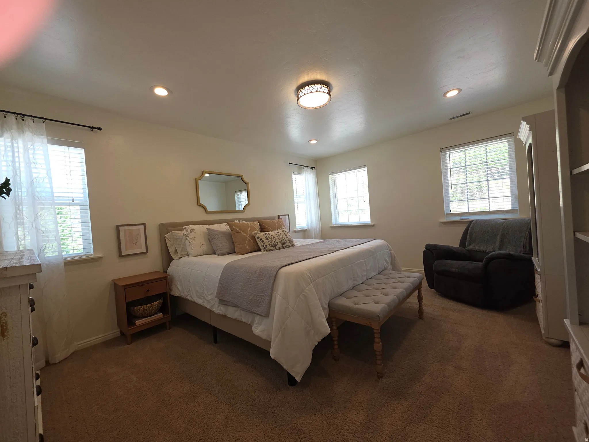 Carpeted bedroom with recessed lighting and a central flush-mount light fixture