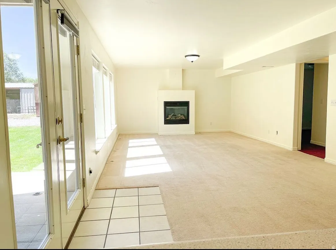 Spacious living area featuring a built-in fireplace, multiple large windows, and walk-out basement with direct patio and back yard.