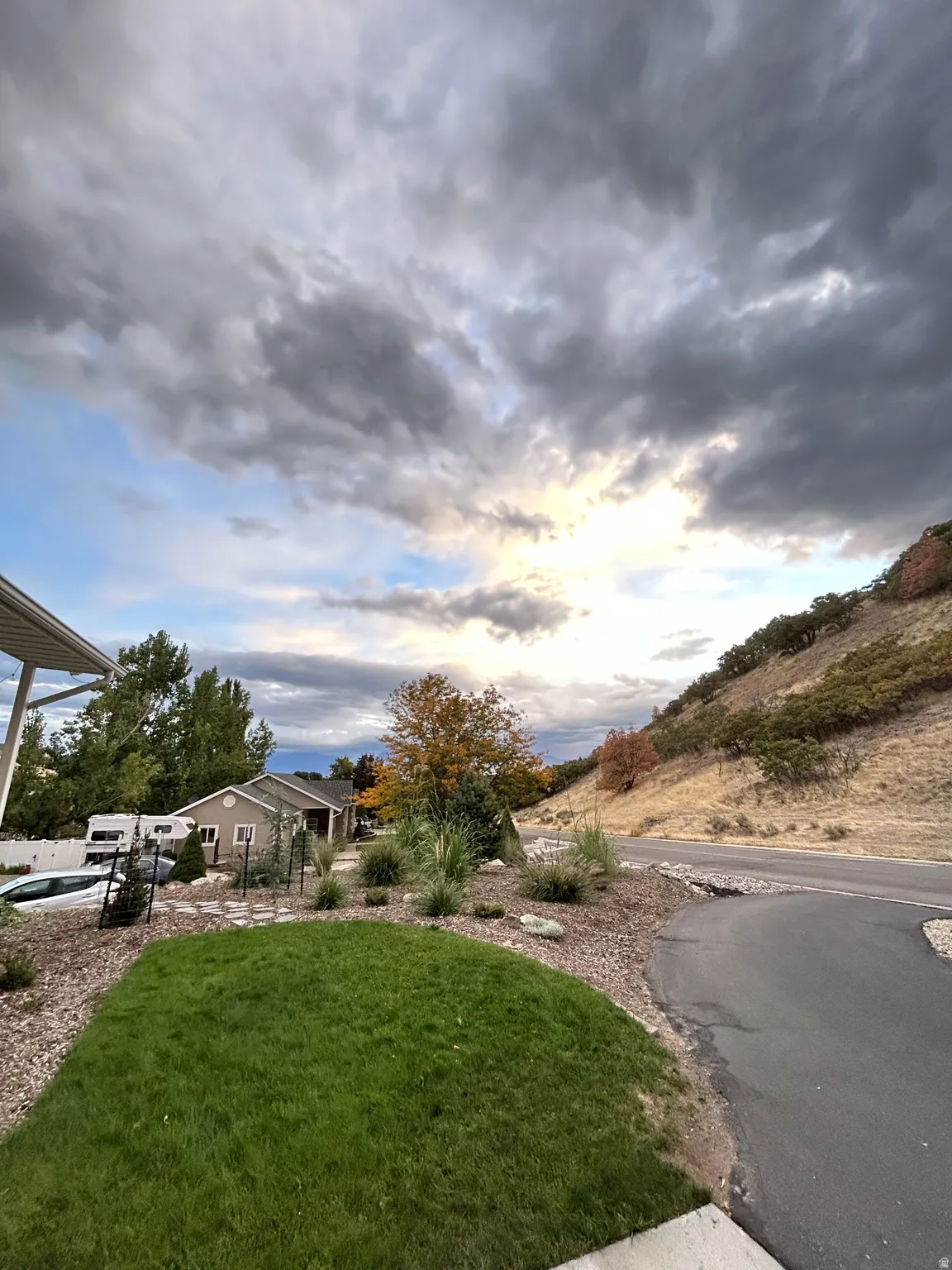Front yard featuring a manicured lawn, decorative rock landscaping, and mature foliage