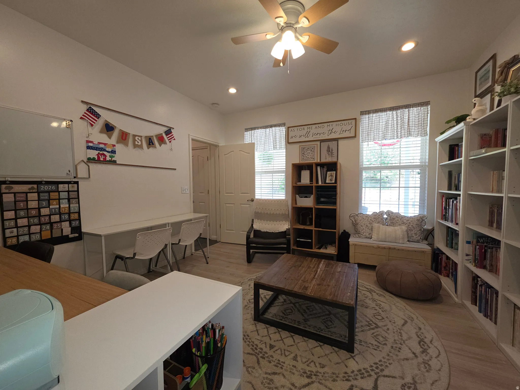 Recessed lighting illuminates this versatile room featuring light wood-finish flooring