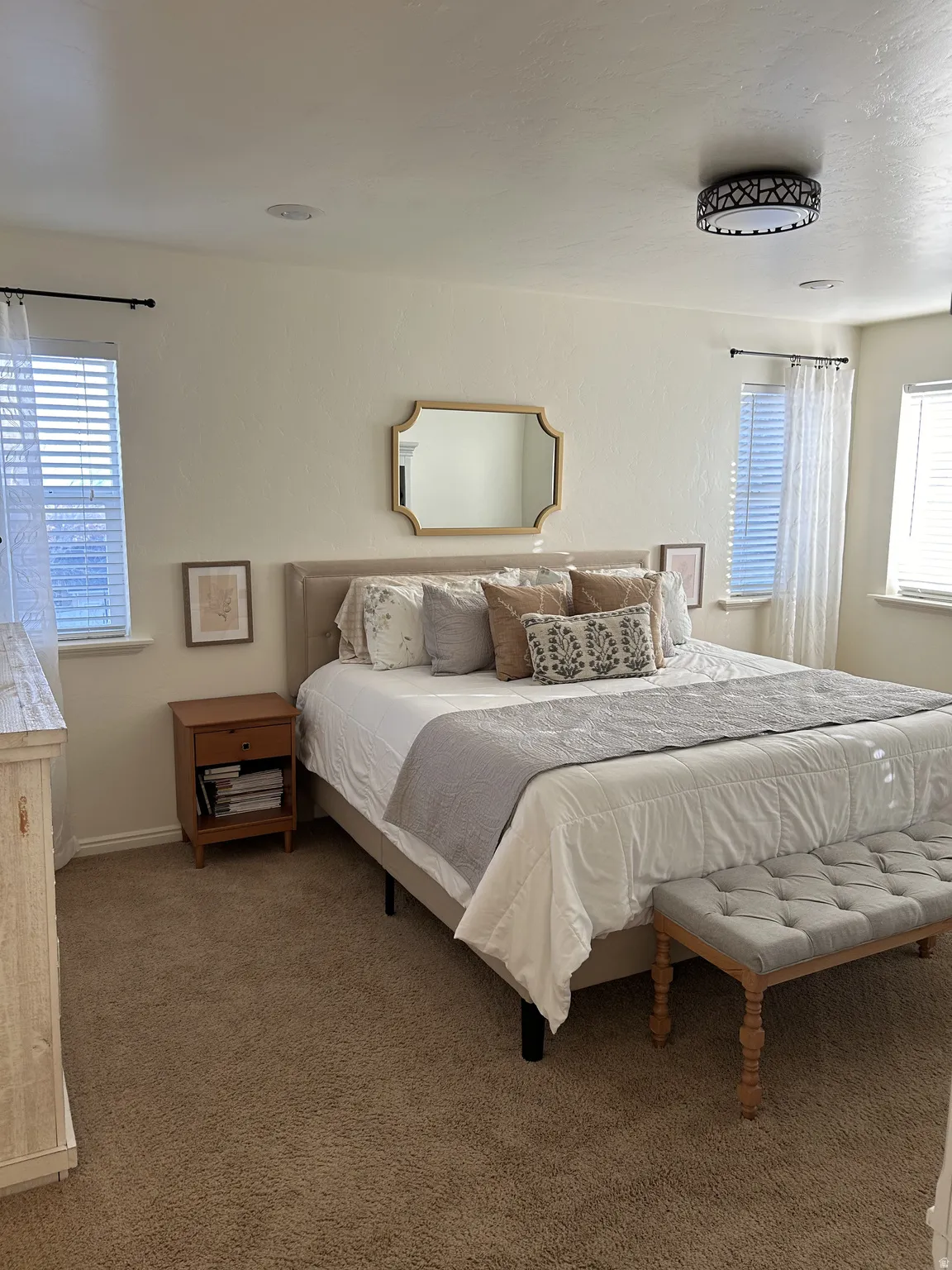 Owner's suite featuring neutral-toned carpeting, multiple windows with blinds, a built-in overhead light fixture, and recessed lighting