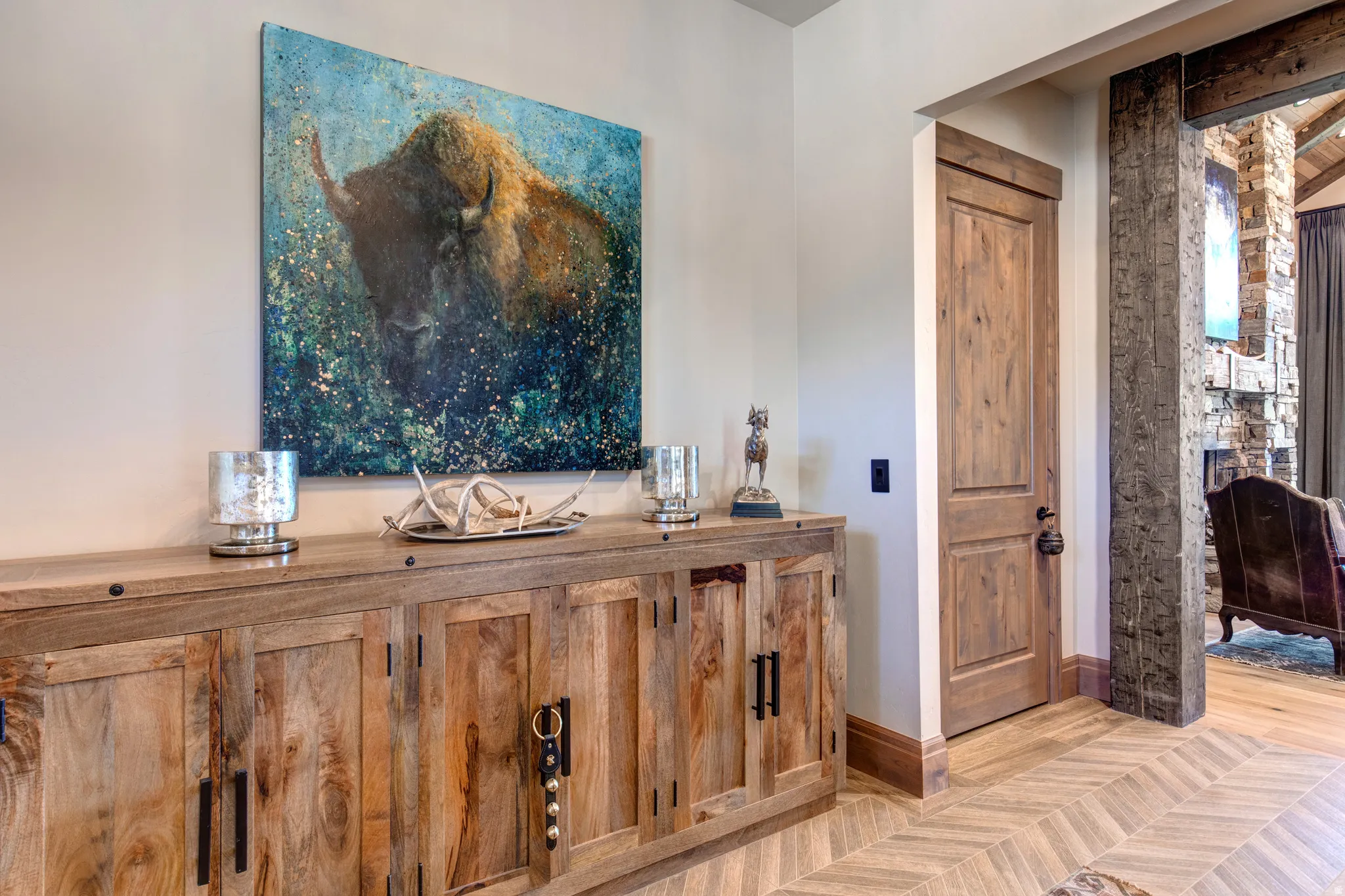 Herringbone wood-finish flooring complements the rustic wooden cabinetry with dark hardware