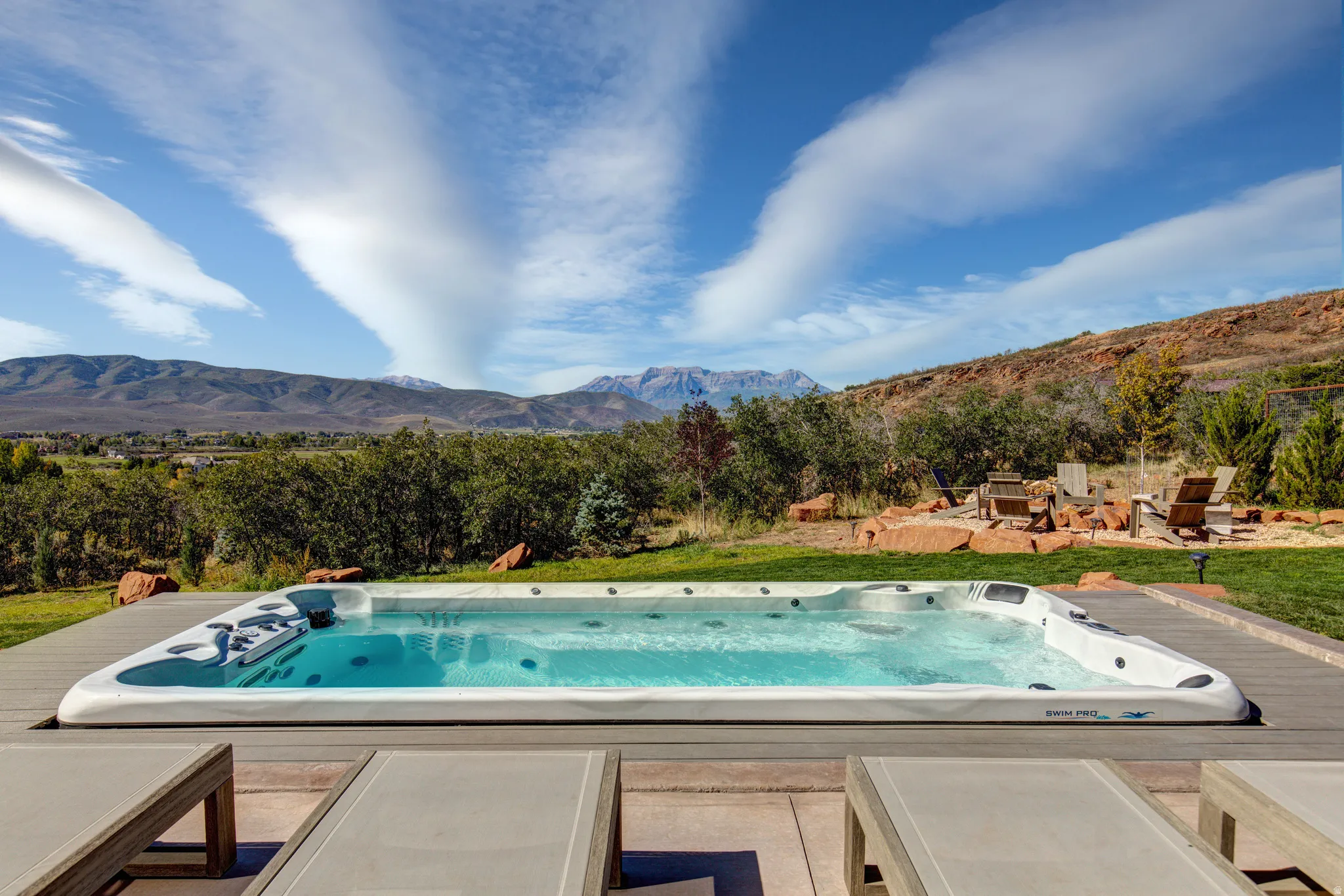 Outdoor swim spa with a surrounding composite deck and a grassy area