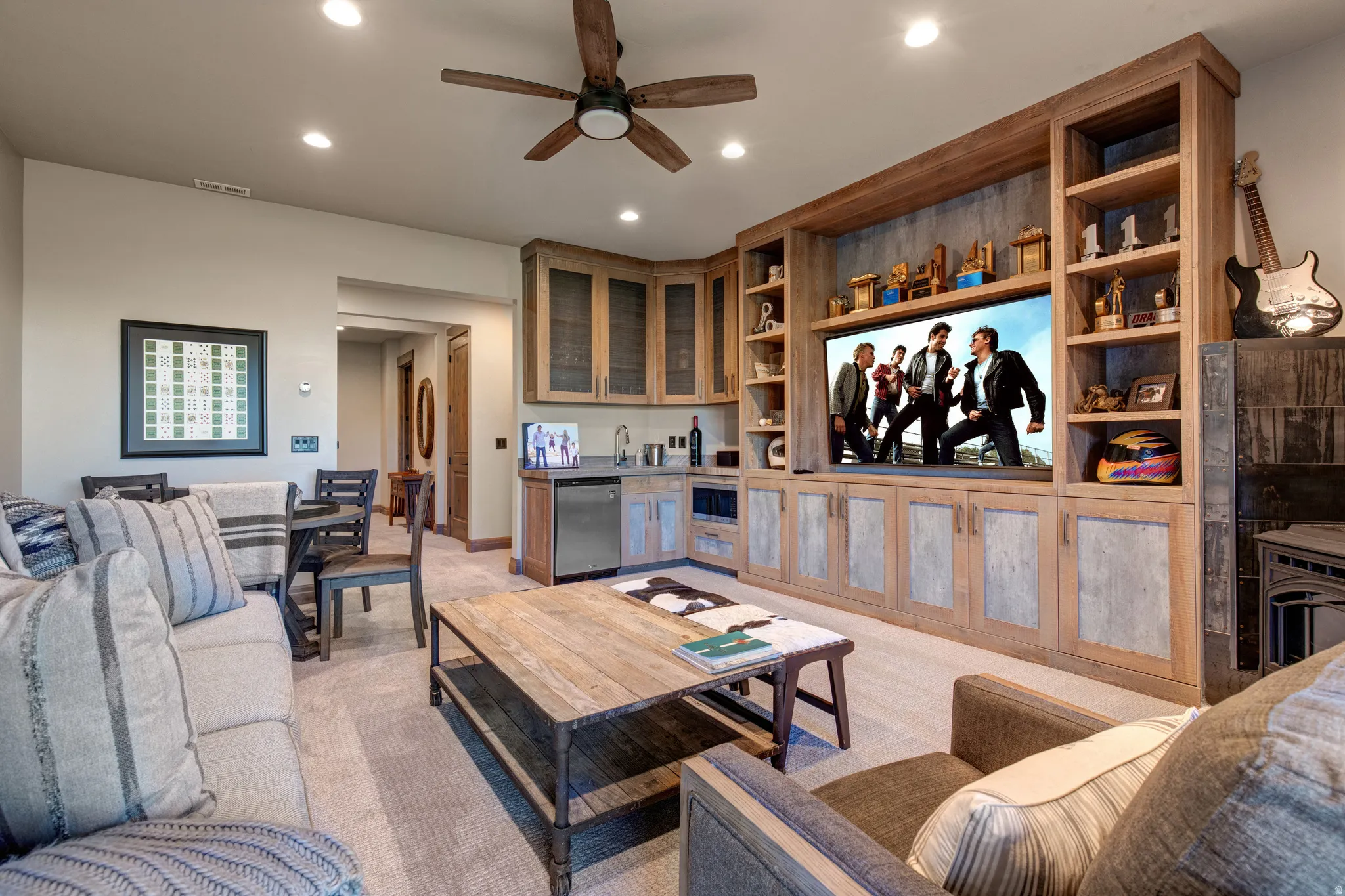 Entertainment area featuring a large built-in media center with shelving, integrated cabinetry, and wood-finish paneling