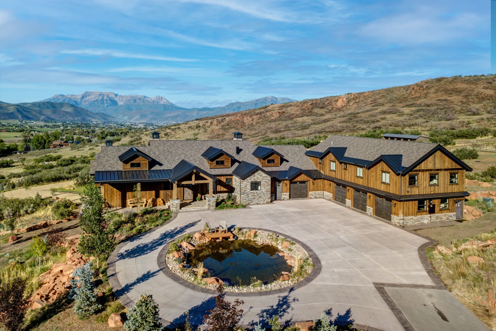 Expansive property featuring a stone and wood-sided exterior with multiple gables and dormers