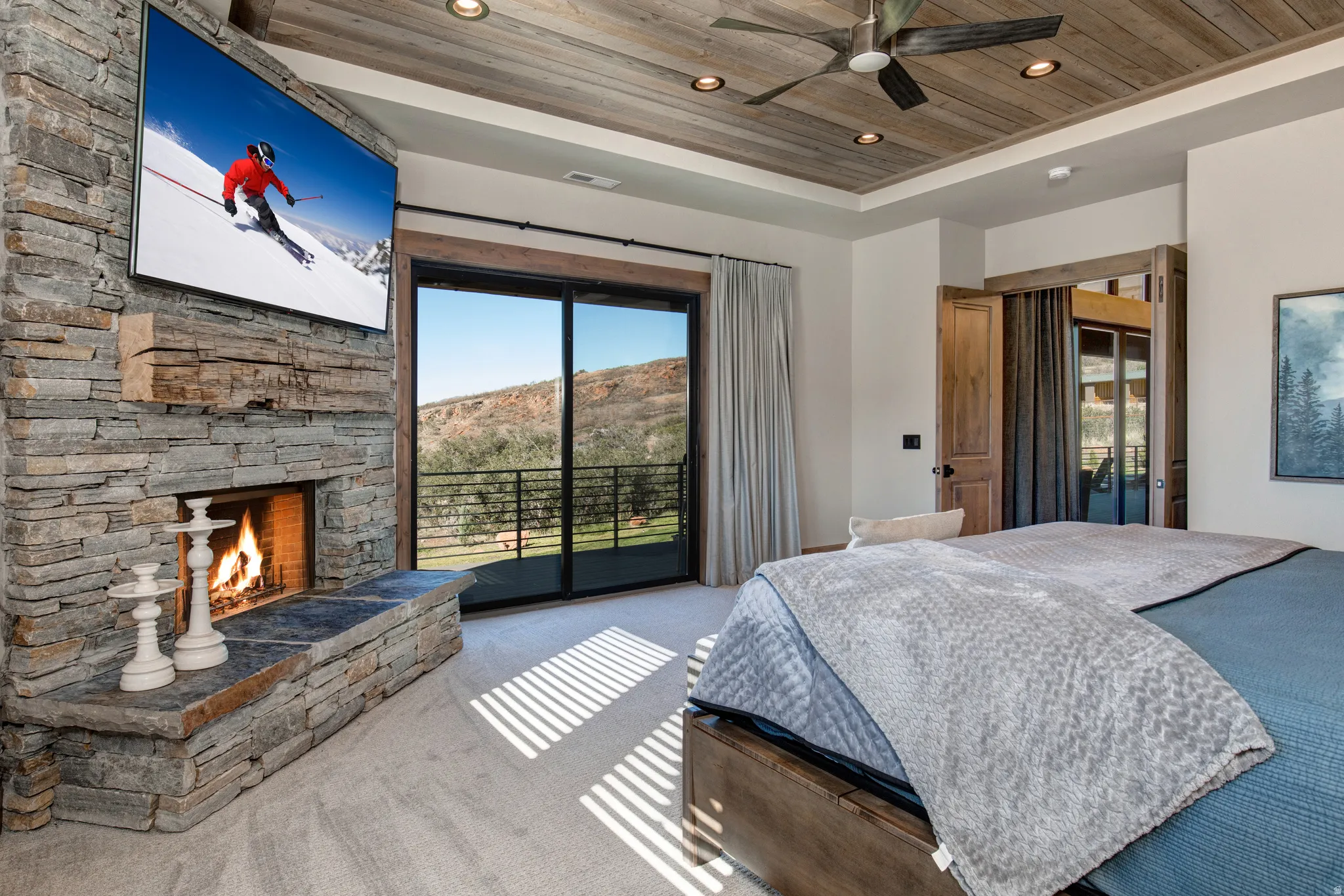 Spacious room featuring a stone fireplace with a wood-beam mantel, wood-plank ceiling, and recessed lighting