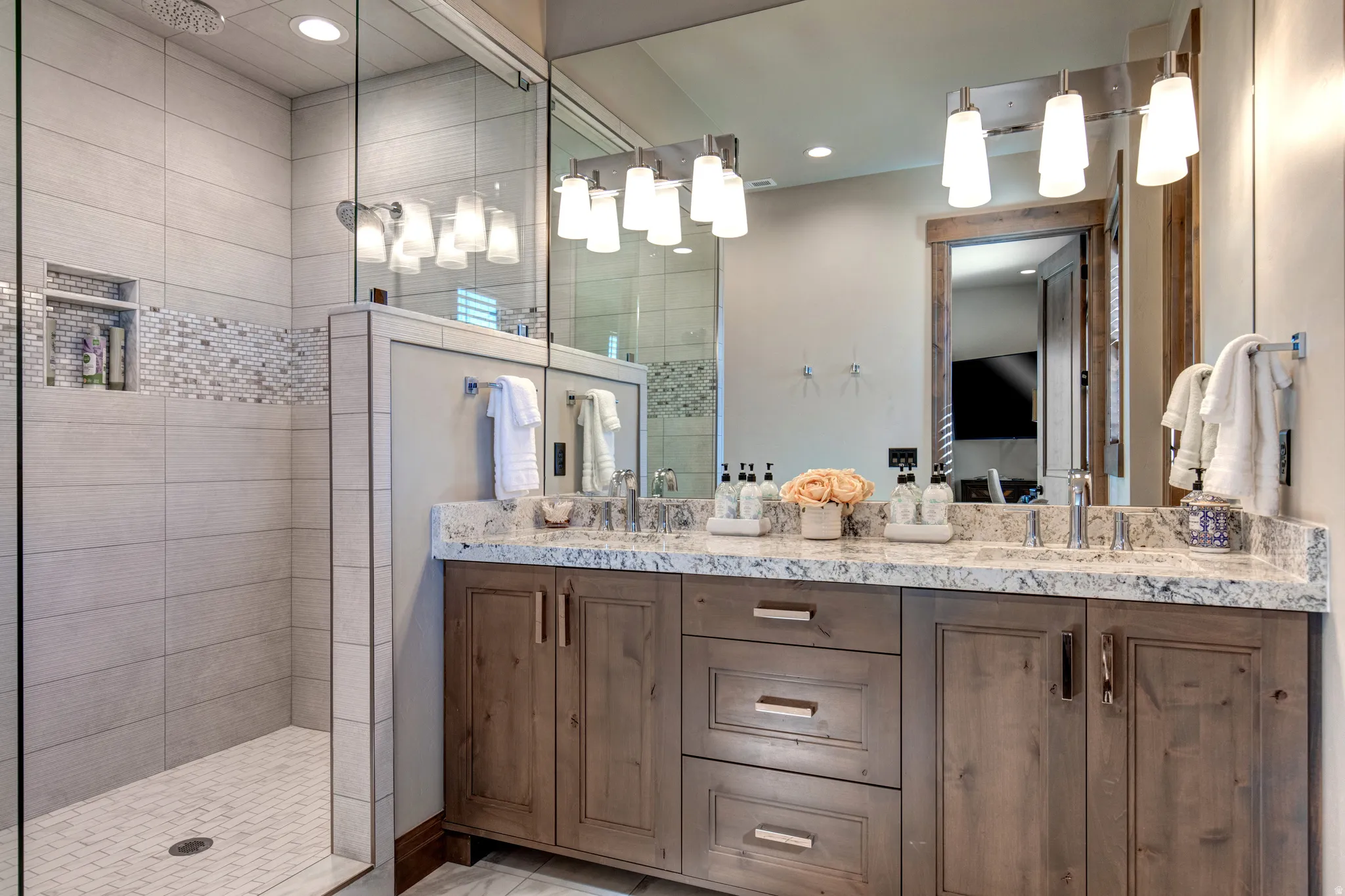 Double vanity with a granite countertop, dual undermount sinks, and wood-finish cabinetry