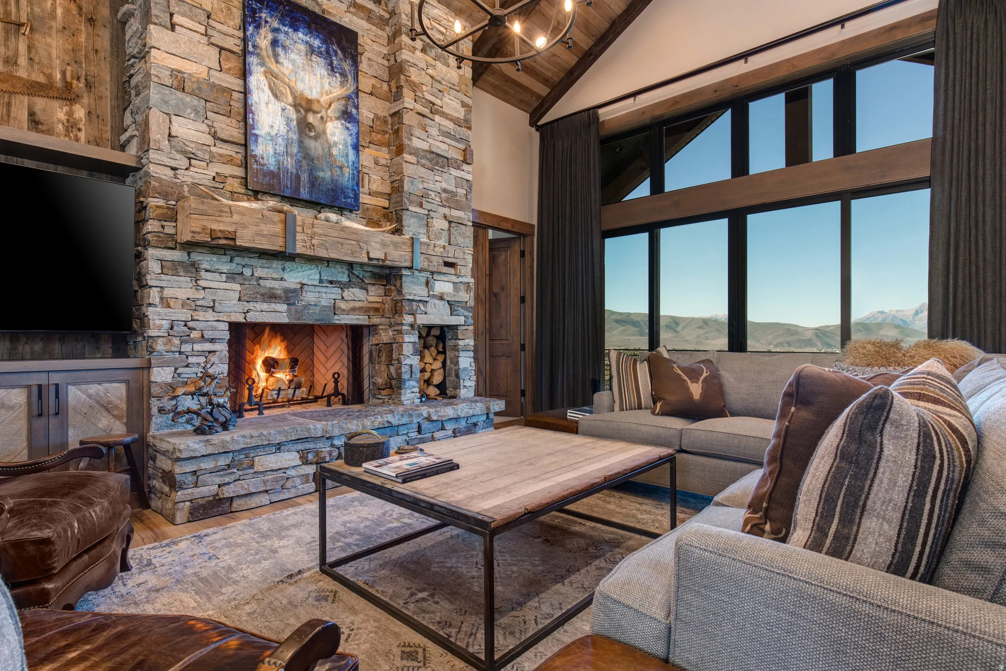 Stone fireplace with a herringbone brick firebox, built-in log storage, and a rustic wood mantel