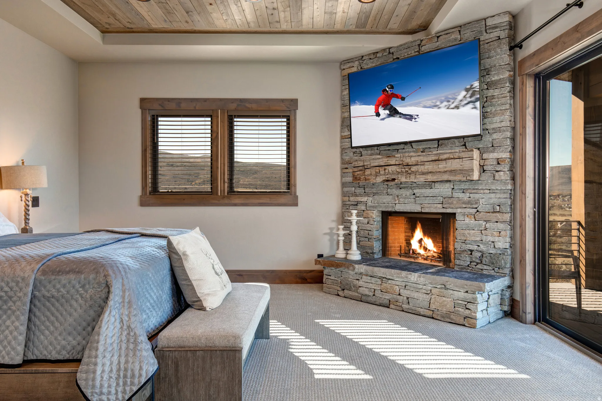 Stone-clad corner fireplace with a rustic wood mantel